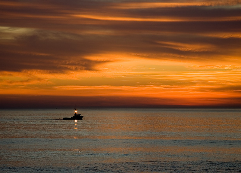 Boat on the ocean at sunset.