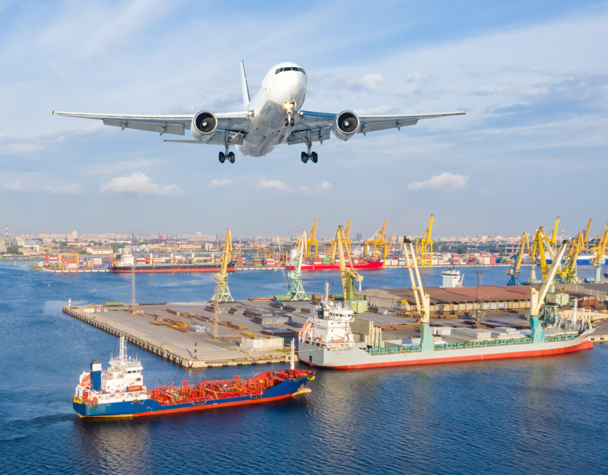 Plane flying over container ships