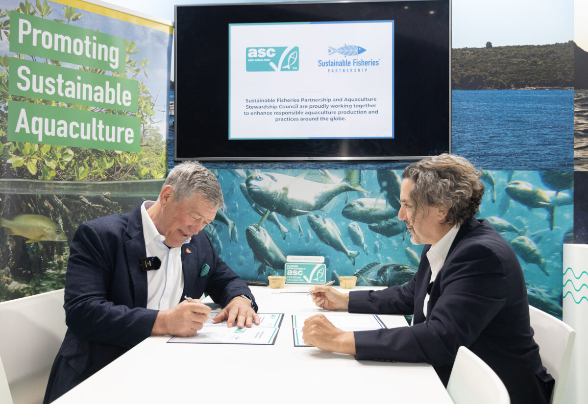 Chris and Jim sitting down signing MOU at Seafood Expo Global.