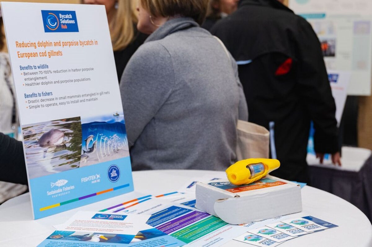 Scene from the 2024 Bycatch Solutions Showcase in Boston, showing a table with literature and samples of fishing gear