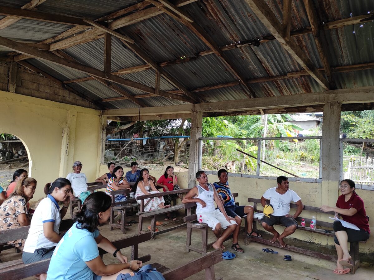 Members of Bluer Seas Philippines speaking to members of a local fishing community in an open-air classroom
