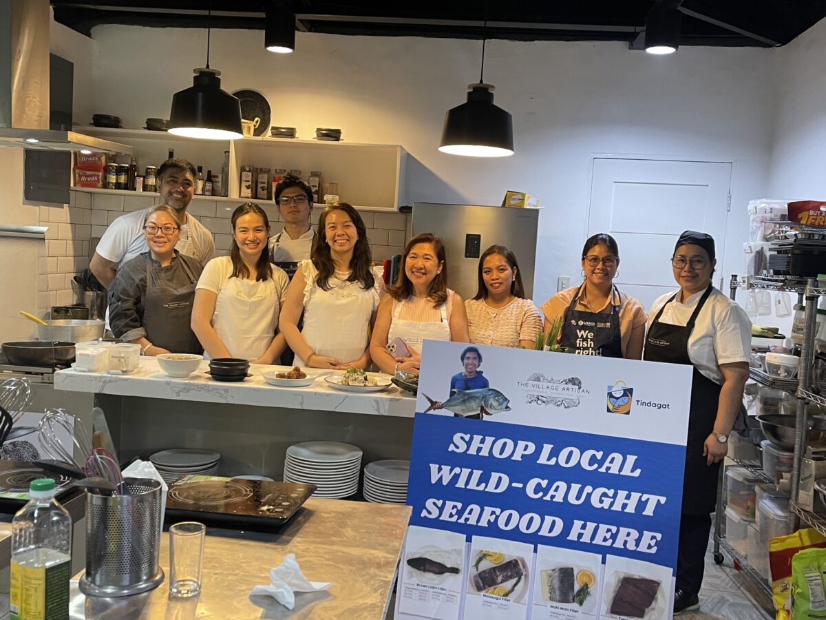 Several people posed behind a seafood counter
