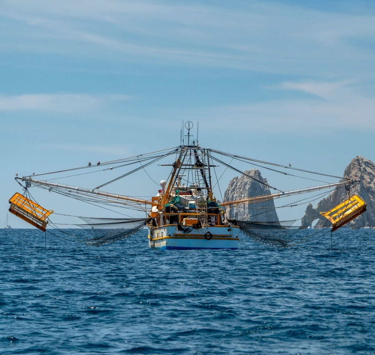 A shrimp fishing boat in the Sea of Cortez, with rocky islets in the background