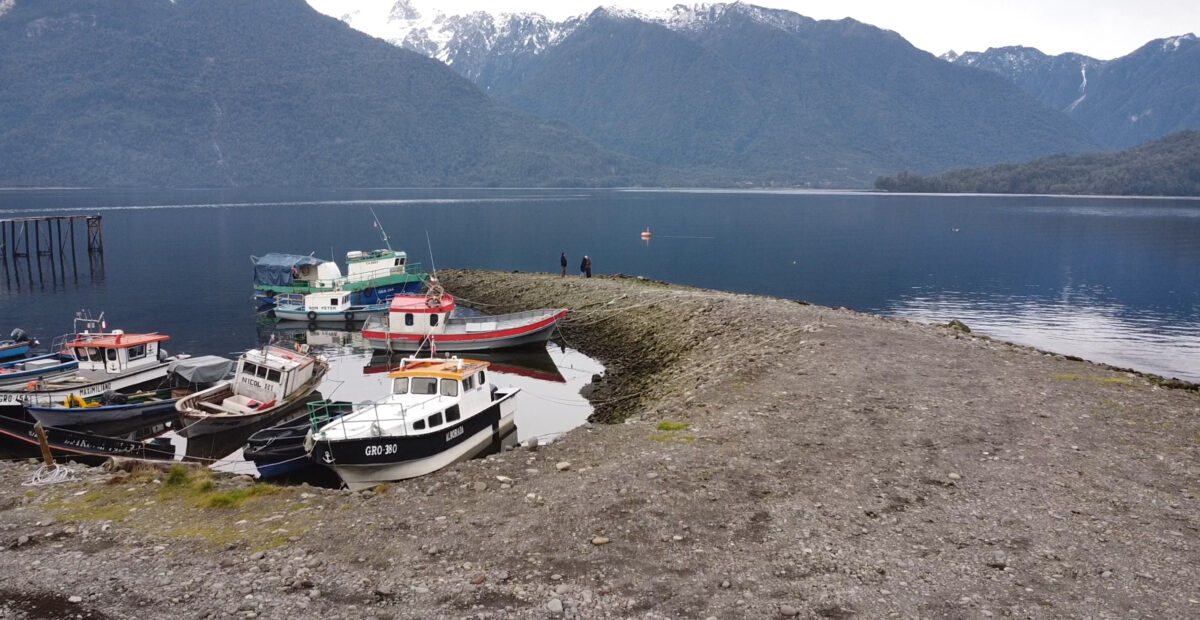 Fishing boats in a cove with snow-covered mountains behind them