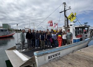 A group of people posing on a lobster boat in Cape Cod Bay
