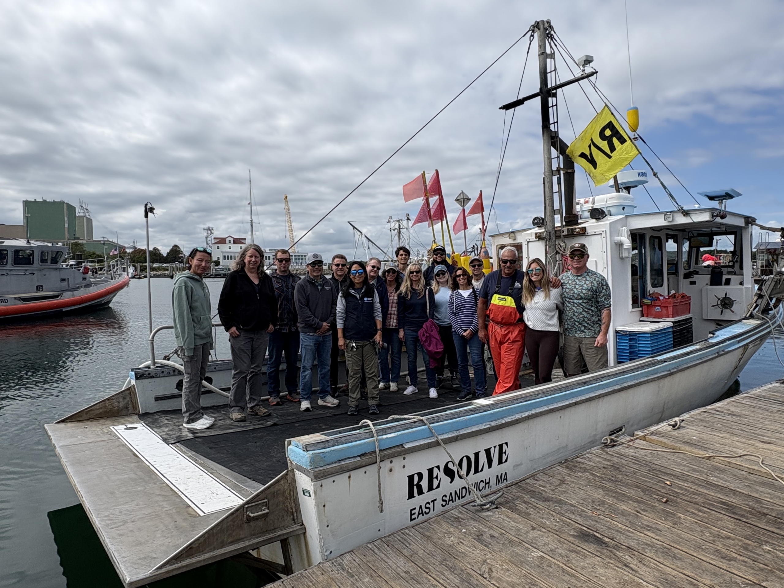 A group of people posing on a lobster boat in Cape Cod Bay