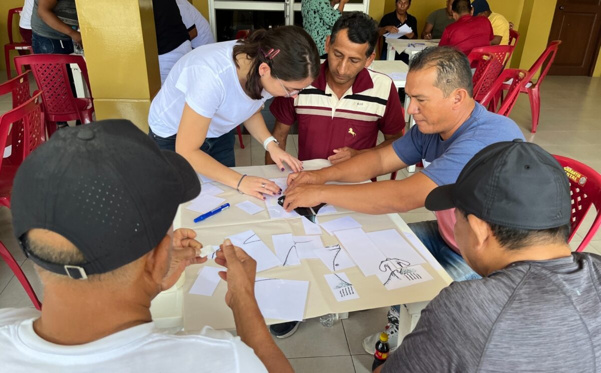 several people gathered around a table working on some documents