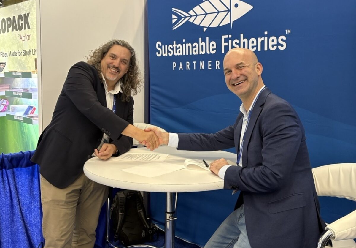 Jim Cannon and Mark Kaplan shaking hands across a table