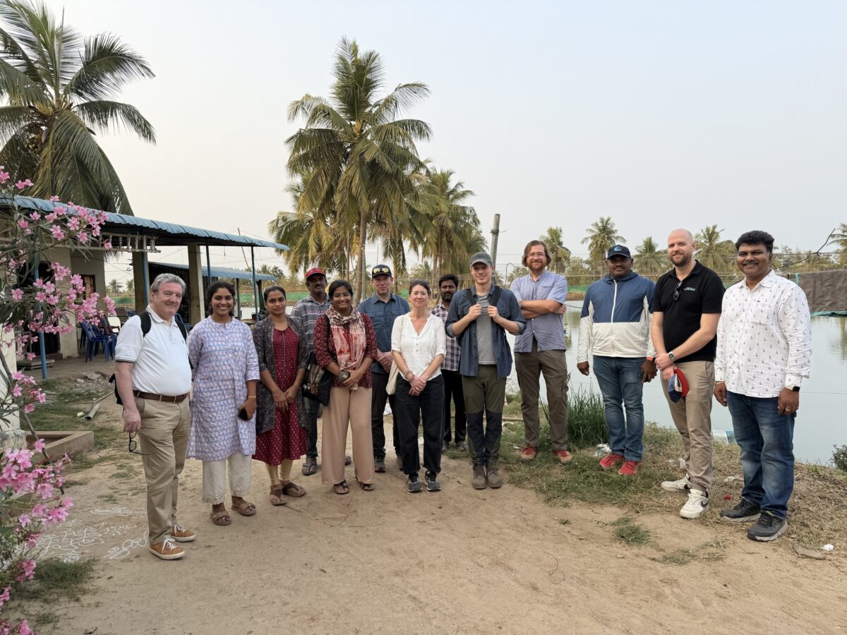 Participants in the India Shrimp Landscape Tour lined up for a photo in front of a shrimp pond