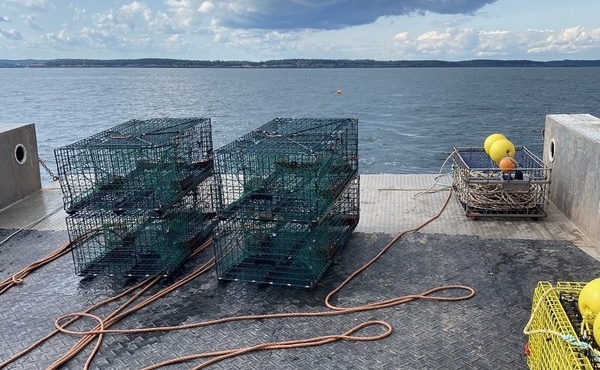 Ashored ropeless gear traps on the deck of a boat, with clouds looming above