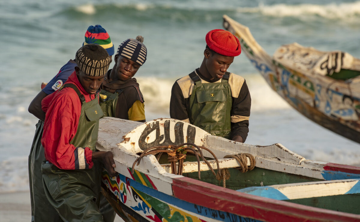 Fishermen on beach with boat in Senegal