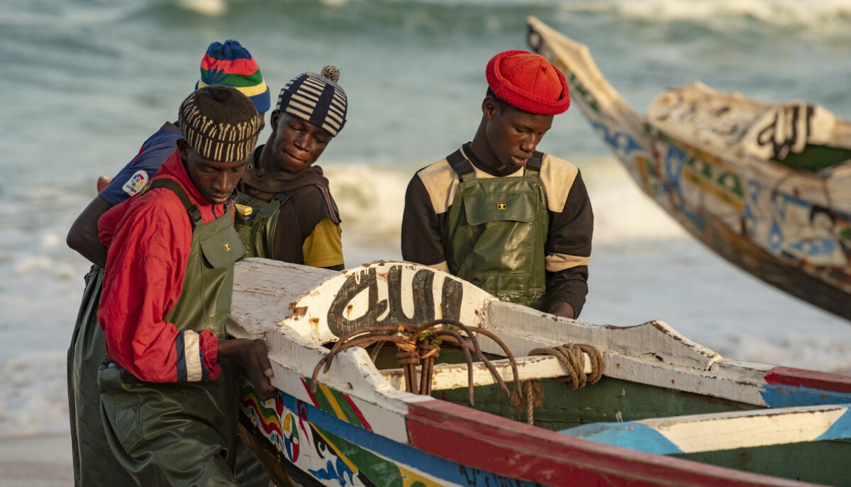 Des pêcheurs avec leur bateau sur une plage au Sénégal